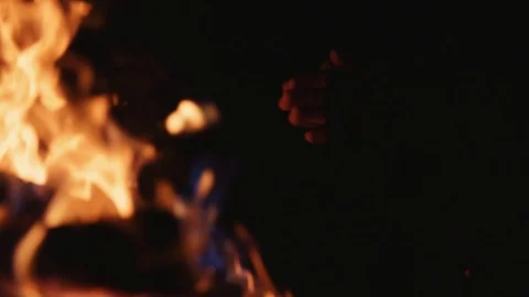 Slow motion young man warming cold hands during winter in front of fire fireside Video stock 100156151