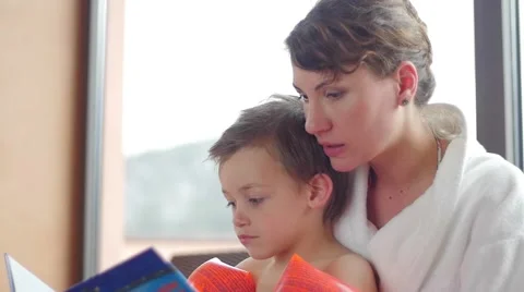 Slow motion of a young mother reading a tale to the son in the spa Stock-Footage 49762847