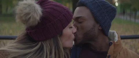 Slow motion of young multi ethnic couple kissing in city park in winter Vídeo Stock 208736040