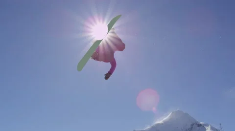 SLOW MOTION: Young pro snowboarder jumping over the sun in half pipe snow park Stock Footage 67224847