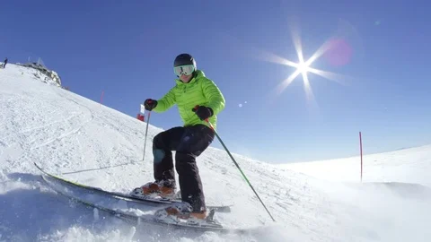 SLOW MOTION: Young skier stop and sprays snow on piste at ski resort in the Alps Stock Footage 80868949