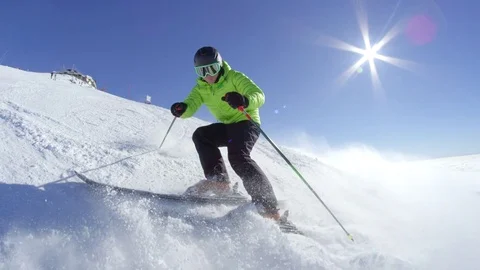 SLOW MOTION Young skier stop and smile while sprays snow in camera at ski resort Stock Footage 80869051