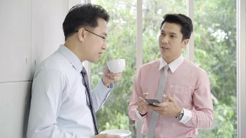 Slow motion - Young smiling men enjoying drinking warm coffee in office. Stock Footage 93960350