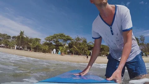 Slow motion: young surfer walks into the ocean with a surfboard Stock Footage 88109215
