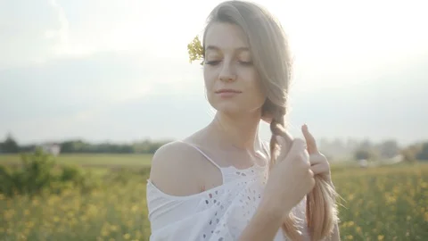 Slow motion young woman stand in field braids hair smile flower feel freedom Stock Footage 112743953