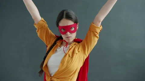 Slow motion of young woman wearing superhero costume red cape and mask moving on Stock Footage