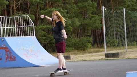 Slow motion of young woman's first successful try on skateboard Stock Footage 203908115