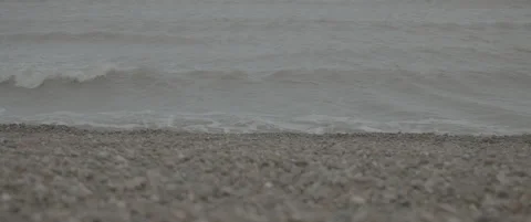 Slow Motion Zoom Between Close-Up and Mid Shot of Waves Washing on Shingle Beach Stock-Footage 320177429