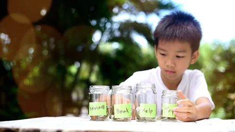 Slow motion zoom in of Boy saving coin  Stock Footage 79612731