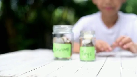 Slow motion zoom in of Boy saving coin Stock Footage