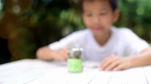 Slow motion zoom in of Boy saving coin  Stock Footage 83062407