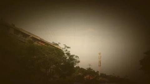Slow Motion Zoom Of Communication Tower And Building Silhouette Under Hazy Sky Stock Footage 331492686