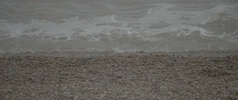 Slow Motion Zoom Sequence from Close-Up to Wide View of Waves on Shingle Beach Stock-Footage 320177443