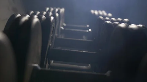 Slow Motion Zoom Into Weights Lined Up On Weight Rack In Industrial Gym  库存影片 123066240