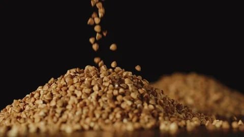 SLOW MOTION: Buckwheat grains pouring on a table - Close Up Vídeos de archivo 103363498