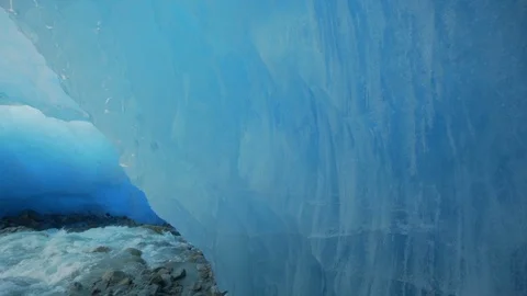 Slow Motion/Forward of Flowing Stream Underneath Large, Blue Tinted Glacier - Stock Footage 113948902