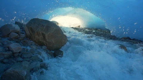 Slow Motion/Left of Large Stream Flowing Over Rocky Ground Through Glacier Cave Stock Footage 113948817