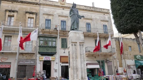 Slow motion,low angle shot of a statue in the square around flags at daylight Stock Footage 89188390