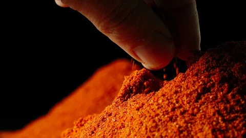 SLOW MOTION: Man's hand taking a pinch of red pepper powder from a pile Stock Footage 107501447