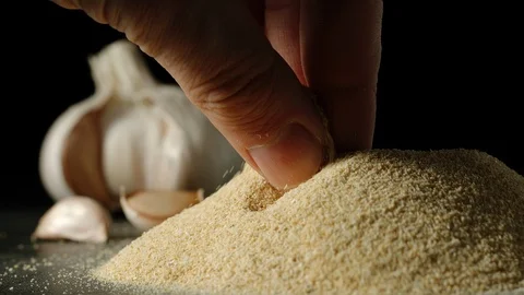 SLOW MOTION: Man's hand taking a pinch of white garlic grains from a pile  Stock Footage 107501522