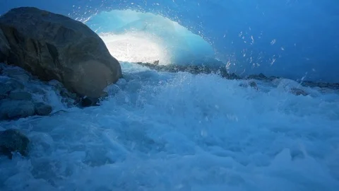 Slow Motion/Pan Up of Splashing, Quick Moving Stream Over Rocky Ground In Stock Footage 113949165