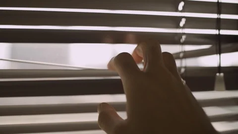 Slow move on a hand holding open venetian blinds and looking outside Stock Footage 109164032