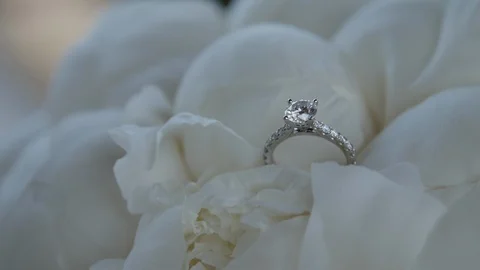 Slow move out engagement ring in white bouquet out of focus Stock Footage 112140601