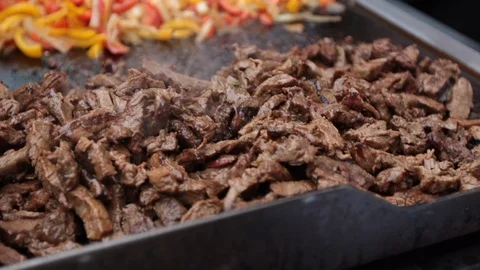 Slow move over textured delicious sizzling meat and peppers Stock Footage 107936341