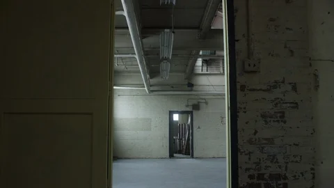 Slow move through door frame revealing a vacant warehouse 스톡 동영상 104438768