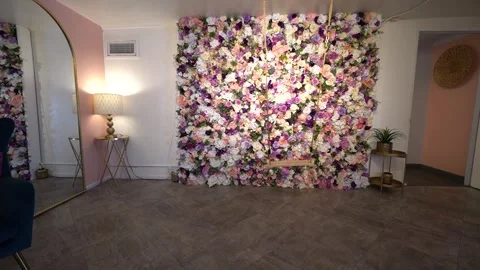 Slow move toward a rope swing and rose flower wall in a pink room Stock Footage 345558721
