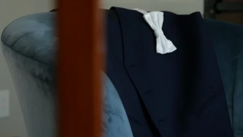 Slow move towards white bow tie and blue vest on couch Stock Footage 112140836