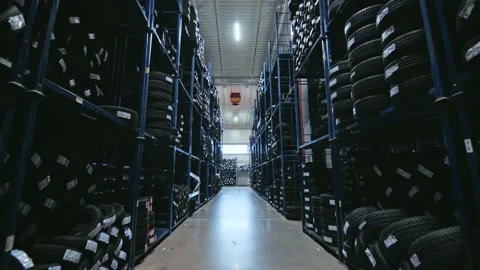 A slow movement between huge racks full of new tyres with tilting up Vídeos de archivo 229670984