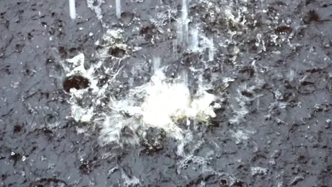 Slow movement of a large pool of water with a splash of water falling from .. Stock-Footage 304494410
