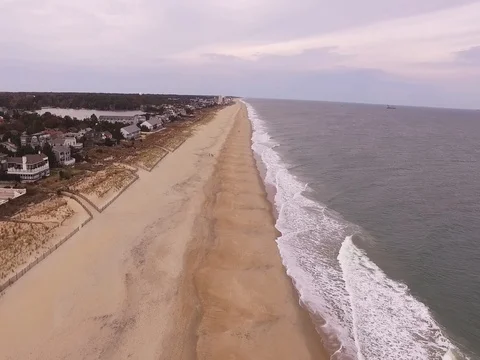 Slow moving aerial over an empty beach during the day. Stock Footage 82631294