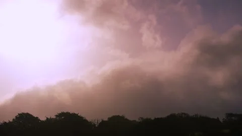 Slow Moving Cloud Timelapse with Sun Diffused Behind Dark Clouds and Stock Footage 316802735
