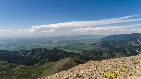 Slow moving clouds from mountain peak overlooking valley Video stock 167124177