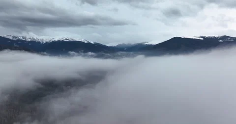 Slow moving drone shoot in thick fog in the morning. Mountains in the background Stock Footage 174370976