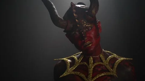 Slow moving female devil with big horns on her head, looking at the camera Stock Footage 138139937