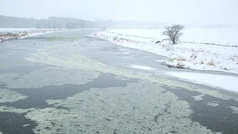 Slow moving  river in winter during snow fall. Stock Footage 168579715