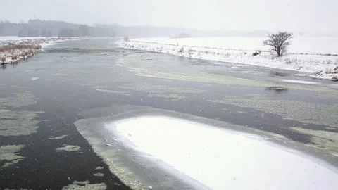 Slow moving  river in winter during snow fall. Stock Footage 168579722