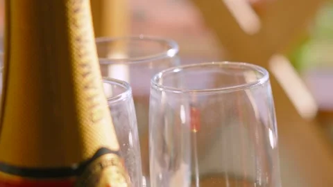 Slow Moving Shot of Champagne Bottle with Glass Flutes 스톡 동영상 326019470