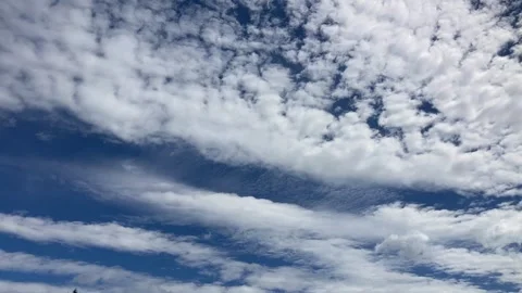 Slow moving white cloud bands in blue sky move to upper right Stock Footage 286167236