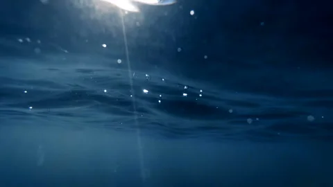 Slow mtoion video from under the water on sea waves and sun light rays Stock Footage