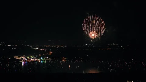Slow orbit around Arnolds Park as fireworks explode overhead, capturing the Stock Footage 312786681