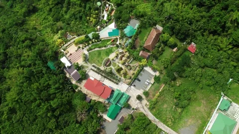 Slow orbit drone footage around Imeldas Garden Resort along the mountains in 스톡 동영상 336720241