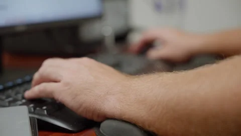 A slow orbit extreme close up around hands typing on a keyboard at a computer Stock Footage 327358252