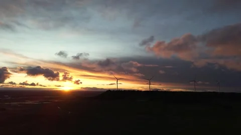 Slow Orbiting Drone Shot Around Wind Turbines on Hill at Beautiful Sunset Stock Footage 325796993