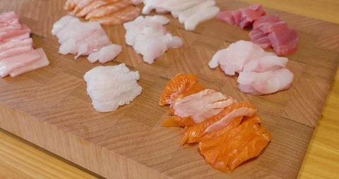 Slow pan across a beautiful presentation of fresh sliced sashimi fish on a board Video stock 115545296