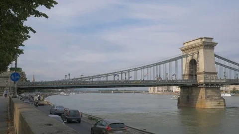 Slow pan across Chain Bridge with tour boat passing under in Budapest, Hungary 動画素材 83648586