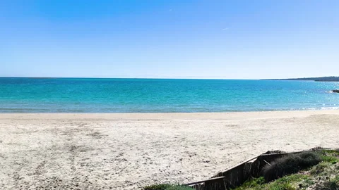 Slow Pan Across Empty La Pelosa Beach with Turquoise Water and Isola Piana o Stock Footage 329791831